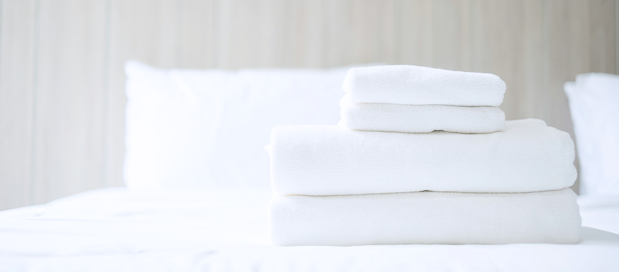 Stack of white towel and Bathrobe on bed in luxury hotel or resort. Laundry, Relax, holiday,